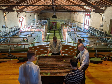 Durfort Vivens winery old grape sorting table with fermentation storage tanks in background