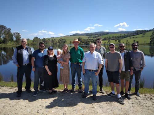 The team stood in front of a lake in the sunshine